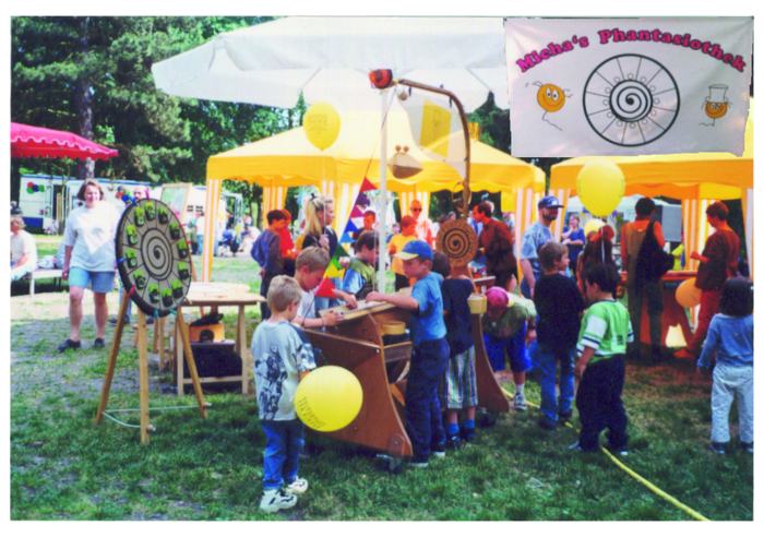 Der Spielepark in seinen Anfängen: gelbe Pavillons, Holzspiele, Banner Micha's Phantasiothek